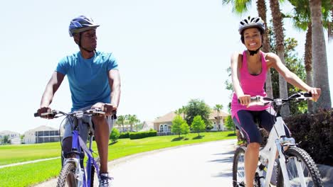 Junge-aktive-afroamerikanische-paar-Übung-Radfahren-im-freien
