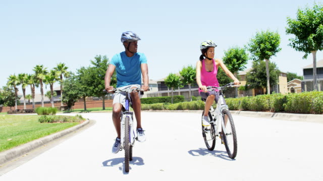 Junge-aktive-afroamerikanische-paar-Übung-Radfahren-im-freien