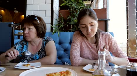 Frau-und-ein-Mädchen-sind-in-einem-Café,-einem-Abendessen-Pizza-essen