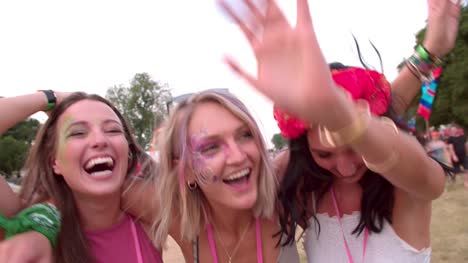 Three-young-female-friends-having-fun-at-a-music-festival