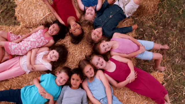Multi-ethnischen-eine-Gruppe-von-Kindern-liegen-im-Kreis-auf-Stroh