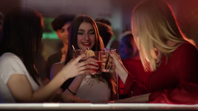 three-girls-at-a-bar-in-a-club-having-a-longdrink