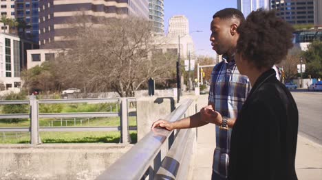 African-American-couple-talking-at-a-waterfront-in-a-city