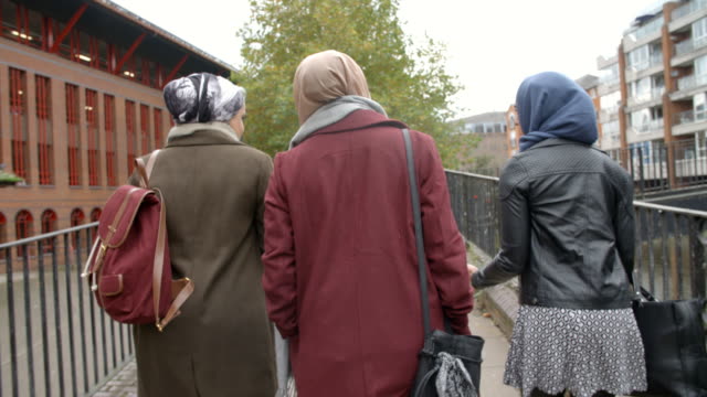 Rückansicht-des-britischen-muslimischen-Freundinnen-zu-Fuß-In-die-Stadt