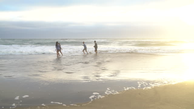 Amigos-en-la-playa-jugando-en-surf