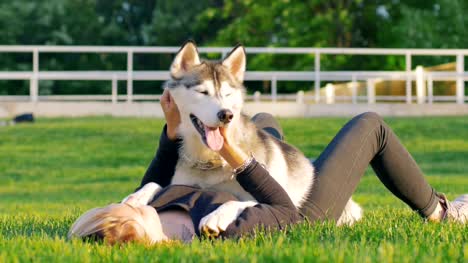 Hermosa-mujer-joven-jugando-con-perro-husky-divertido-al-aire-libre-en-el-Parque