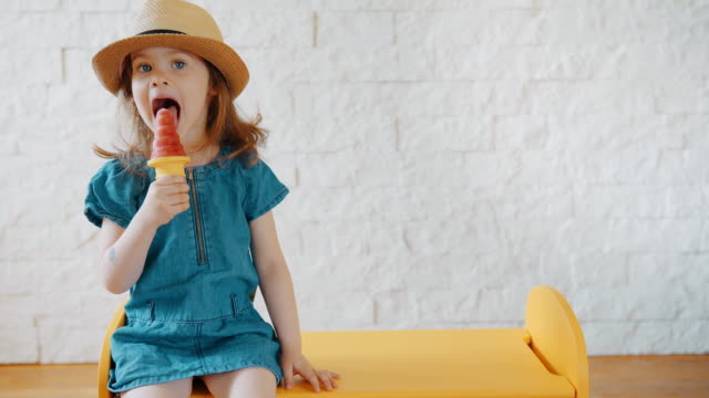 niedliche-Mädchen-essen-Eis-während-des-Wartens-auf-Sommerurlaub