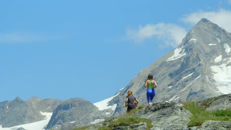 Three-women-run-up-a-high-altitude-mountain-range.