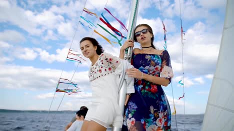 Stylish-girls-posing-happily-on-sailboat-while-having-party