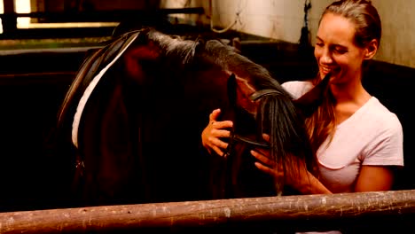 Mujer-acariciando-caballos-en-establo-4k