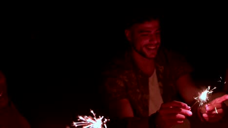 Young-multi-ethnic-hipster-friends-celebrating-with-sparklers-at-night