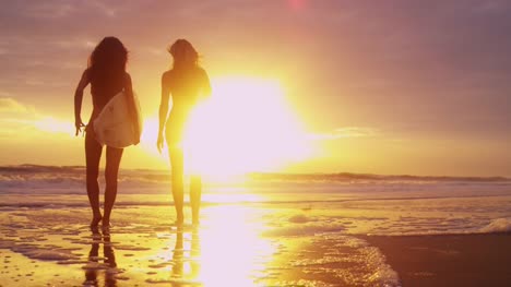 Schöne-schlanke-Surfer-Girls-Strand-Sonnenuntergang-Blick-auf-Wellen