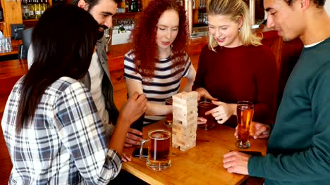 Group-of-fiends-playing-jenga-while-having-beer-4k