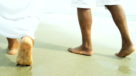 Happy-ethnic-couple-legs-and-feet-walking-barefoot