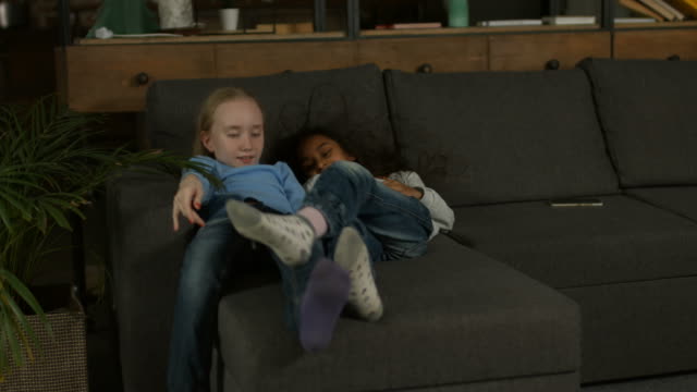 Zwei-Rassen-Mädchen-spielen-auf-der-couch