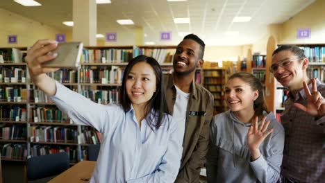 Group-of-international-students-have-fun-smiling-and-making-selfie-photos-on-smartphone-camera-at-university-library.-Cheerful-friends-have-rest-while-preapre-project-together