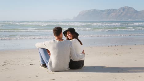 Rear-View-Of-Romantic-Couple-On-Winter-Beach-Vacation