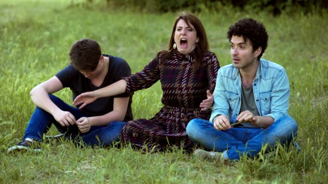 portrait-of-Young-careless-friends-on-the-lawn-sing,-laugh-and-have-fun