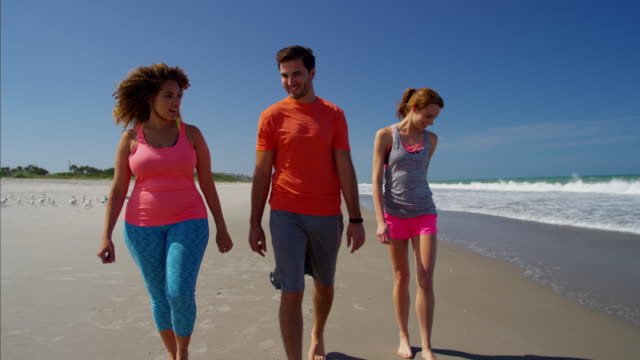 Multi-ethnic-friends-enjoying-fitness-activity-on-beach