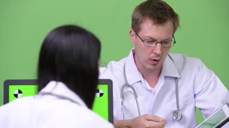 Young-Asian-woman-doctor-having-meeting-with-young-man-doctor