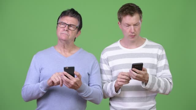 Senior-handsome-man-and-young-handsome-man-using-phone-together