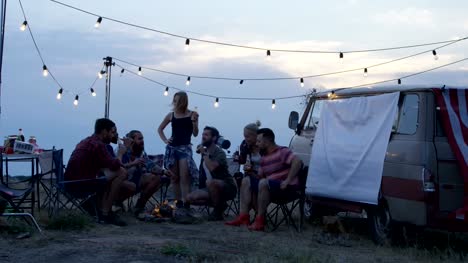 Friends-having-rest-in-campsite-having-drinks