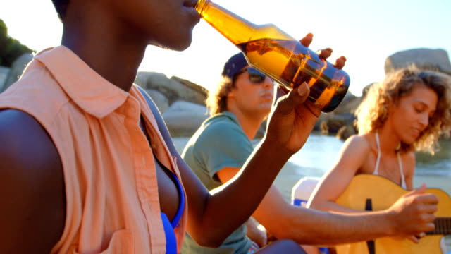 Group-of-friends-having-beer-in-the-beach-4k
