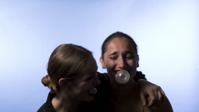 Zwei-junge-Frauen-weht-Bubble-Gum-und-lachen