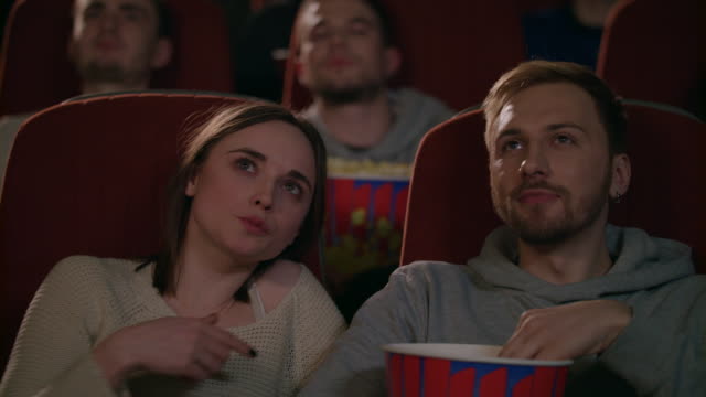 Junges-paar-Film-im-Kino-genießen.-Paar-Essen-Popcorn-und-Film-diskutieren