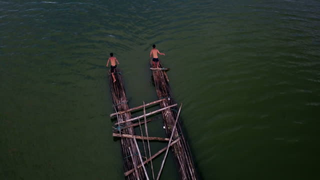 Vista-aérea-de-niños-saltando-en-el-agua-en-el-lago-al-atardecer,-en-concepto-de-la-vida-de-campo-alegre