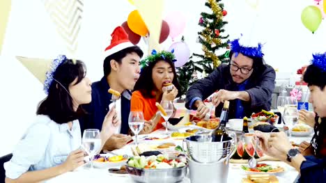 Grupo-de-pueblos-asiáticos-cenando-en-fiesta-de-año-nuevo-juntos.-Gente-sentada-alrededor-de-una-mesa-y-comer-juntos.-Personas-con-el-concepto-de-fiesta-de-año-nuevo.