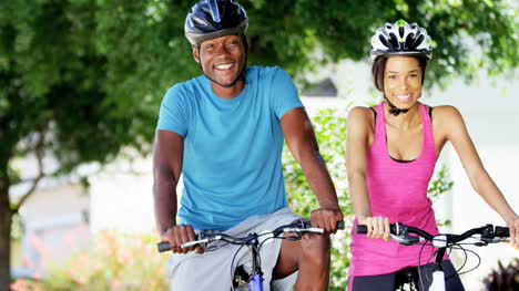 Portrait-ethnic-couple-cycling-to-keep-fit-outdoors