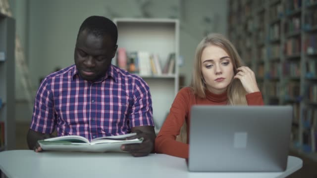 Interracial-students-leafing-through-a-book
