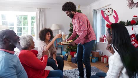Retratos-de-padres-con-hijos-adultos-haciendo-un-brindis-con-champán-mientras-celebran-Navidad-juntos