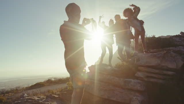Man-taking-picture-of-his-friends-during-hike