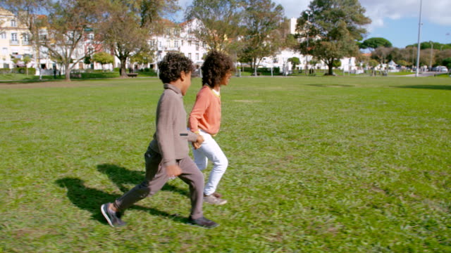 Freudige-afrikanischen-amerikanischen-Freunden-laufen-und-Hand-in-Hand-im-park