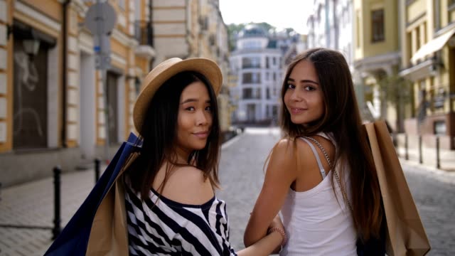 Asiatische-und-kaukasischen-Shopper-Freunde-lächelnd-auf-cam