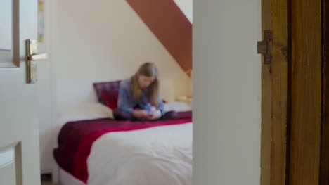 Young-girl-on-bed-messaging-on-smartphone-(Blurred)