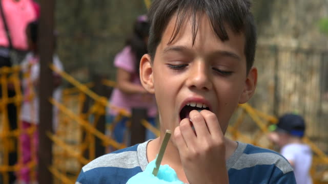 Young-Boy-Eating-At-Playground