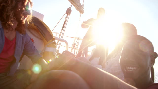 Girl-friends-drinking-beer-on-sunset-yacht-cruise-with-sunflare