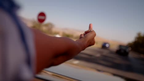Hipster-Girl-flipping-the-finger-from-the-backseat-of-convertible-car