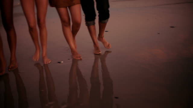 Gruppe-von-Freunden-Barfußlaufen-und-glücklich-auf-Sandstrand