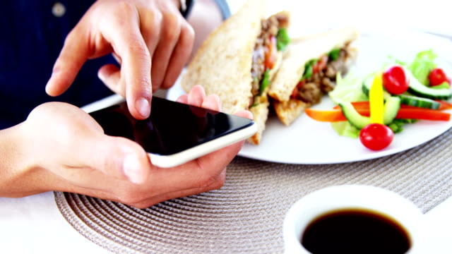 Man-in-lunch-bar-with-smartphone-and-coffee