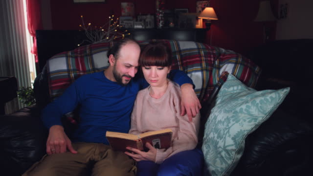 4k-Authentic-Shot-of-a-Couple-Reading-Book-on-Couch