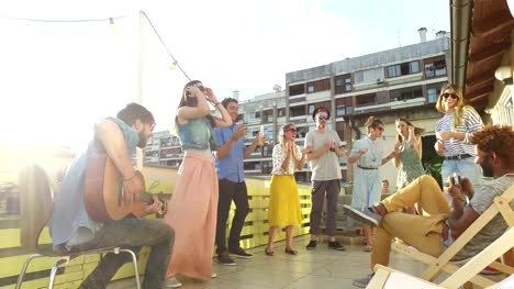 Musiker-spielt-Gitarre-auf-der-Dachparty,-Leute-tanzen-und-fotografieren