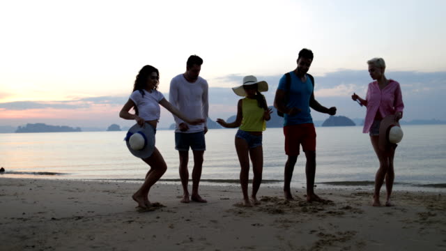 Gente-bailando-en-la-playa-al-atardecer,-amigos-felices-Mix-Race-Group-turistas-Mar-vacaciones