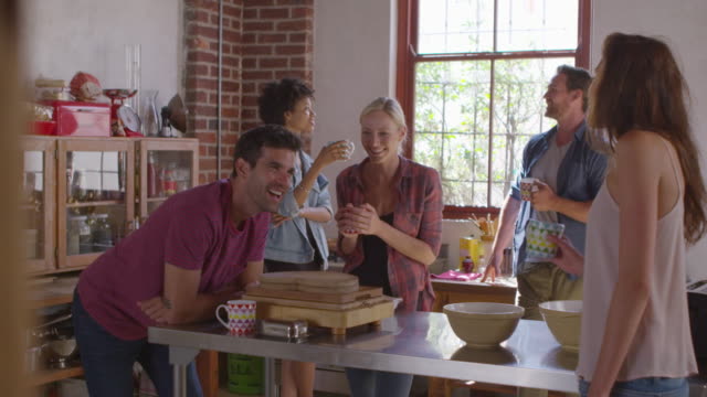 Cinco-amigos-riendo-sobre-café-en-la-cocina,-filmados-en-R3D