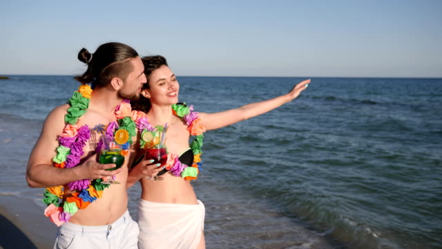 Strand,-Panorama,-liebenden-Mann-und-ein-Mädchen-gehen-mit-Cocktails,-happy-Freunde-in-hawaiian-Lei-umarmen-und-viel-Spaß-im-Sommer-Erholung