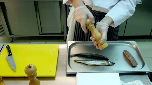 Koch-würzen-und-Salzen-der-Fische-auf-einem-Tablett