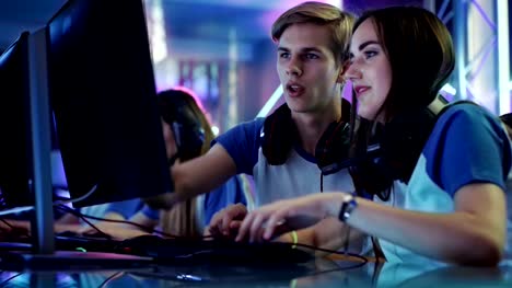 Boy-and-Girl-Gamers-Actively-Thinking/-Discussing-Game-Strategy/-Tactic,-They're-In-Internet-Cafe-or-on-Cyber-Games-Tournament.
